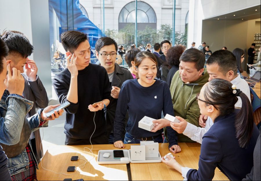 Apple-AirPod-Pro-launch-Shanghai-guests-with-team-member-at-product-table-10302019.jpg